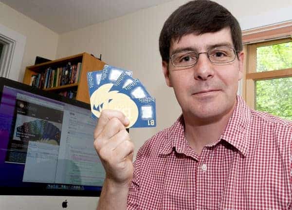 Gavin Andresen mostrando una serie de tarjetas de Bitcoin